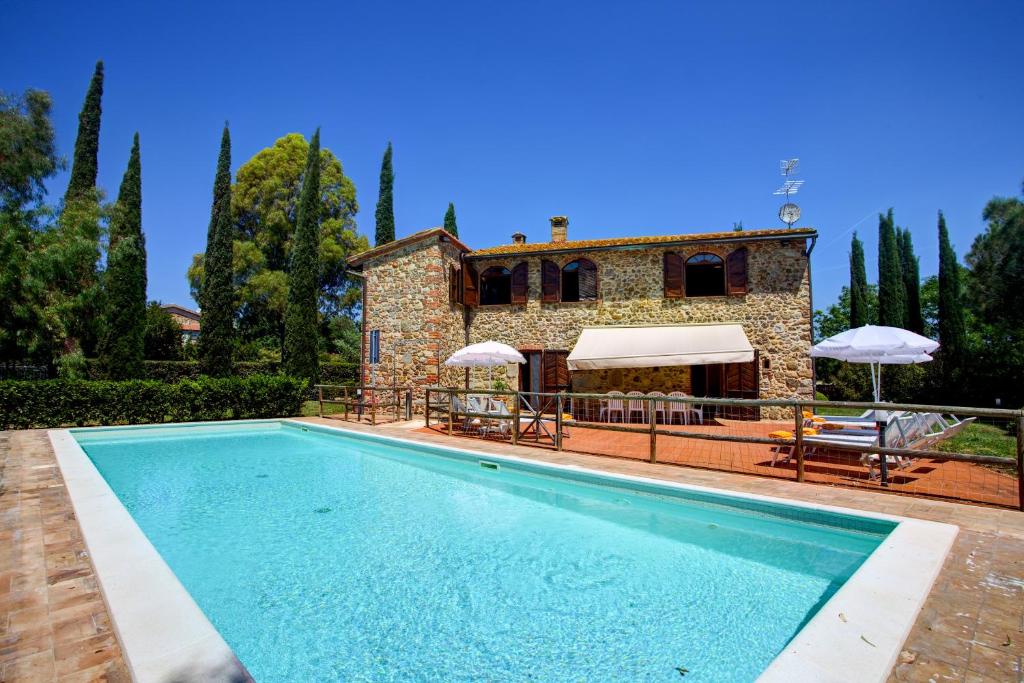 a villa with a swimming pool in front of a house at LA MAGIA 8&2, Emma Villas in Gavorrano