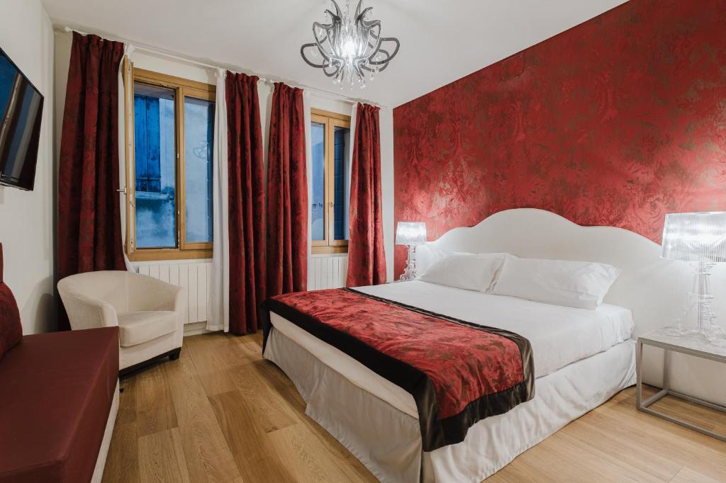 a bedroom with a bed and a red wall at Dimora Capuleti in Venice