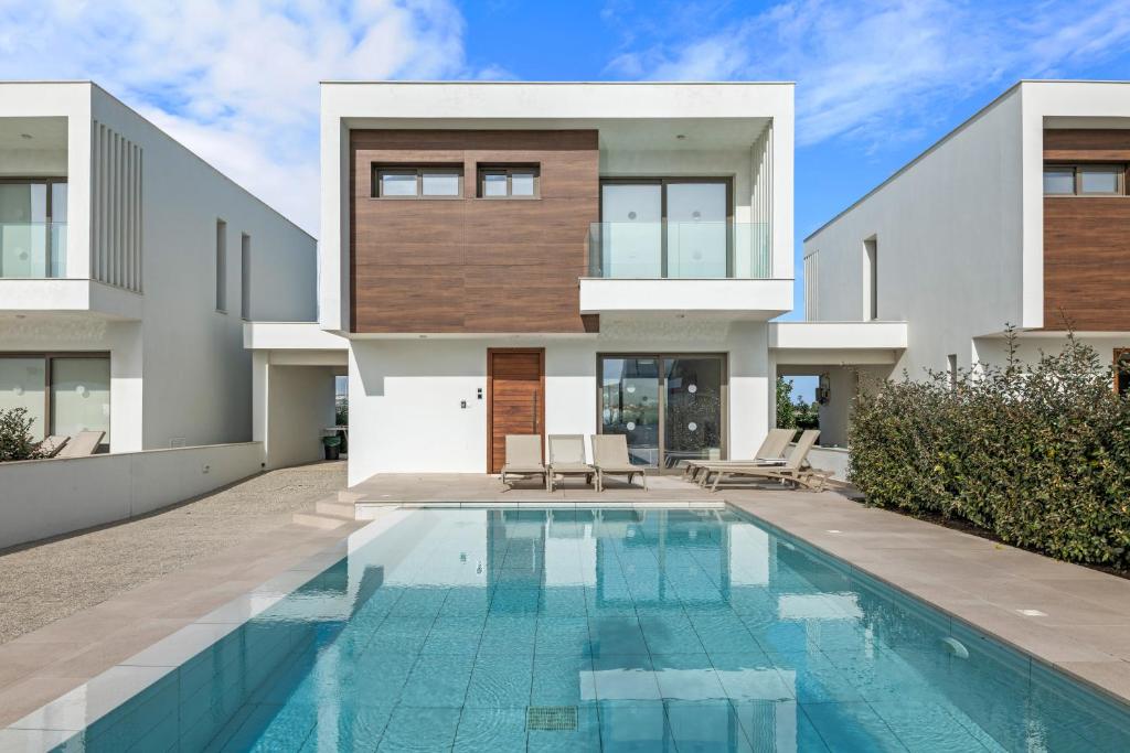 une maison avec une piscine devant dans l'établissement Serenity Waves Villa 11, à Larnaka
