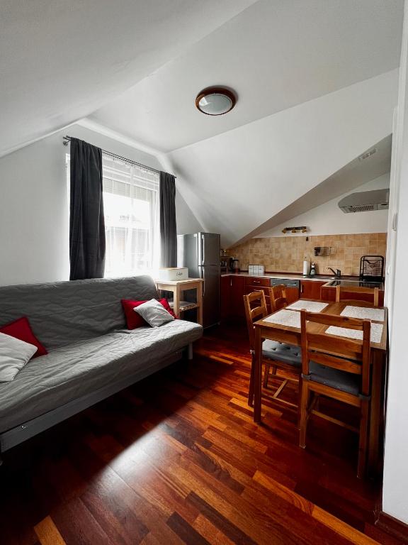 a bedroom with a bed and a table and a kitchen at Apartament Topolowa 2 in Dębki
