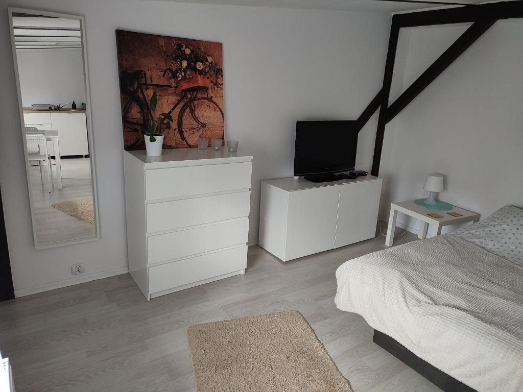 sypialnia z łóżkiem, telewizorem i lustrem w obiekcie Apartament Mariacka w Bydgoszczy