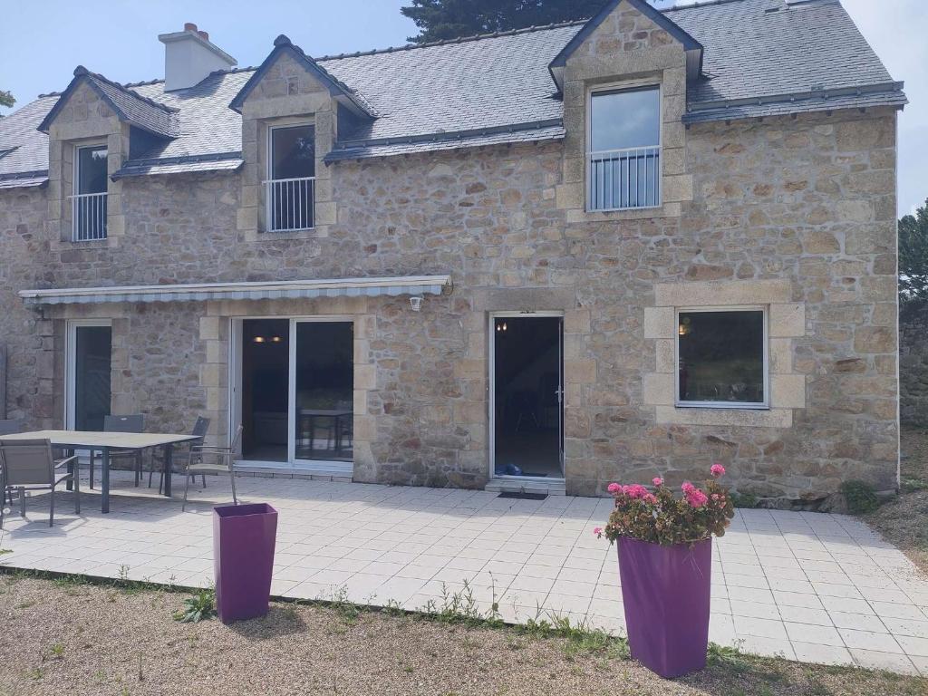 une maison en pierre avec deux vases violets dans l'établissement 018 6 KERNERS maison pour six personnes à louer avec jardin partagé, à Arzon