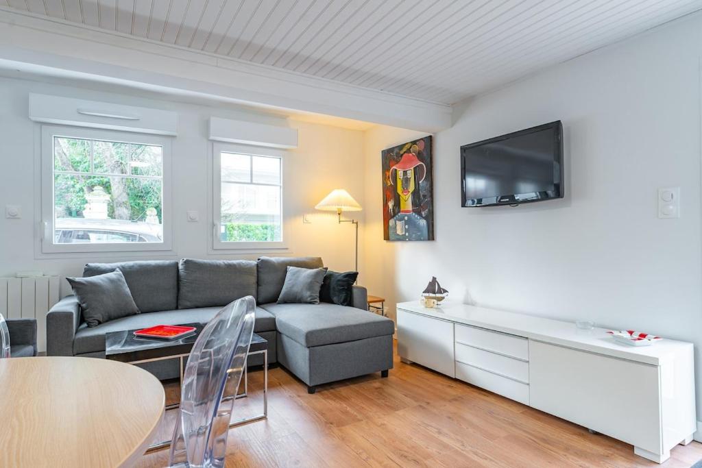 un salon avec un canapé et une télévision dans l'établissement Arcachon centre 4 couchages accès plage, à Arcachon