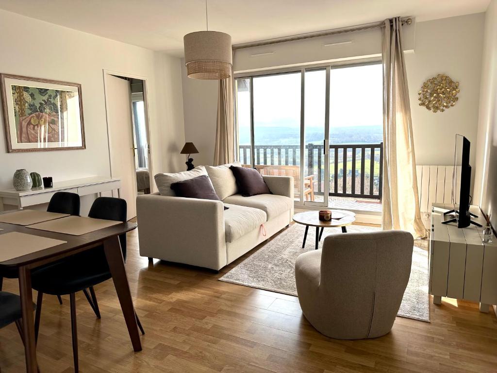 una sala de estar con un sofá y una mesa en Appartement terrasse vue mer/campagne, en Blonville-sur-Mer