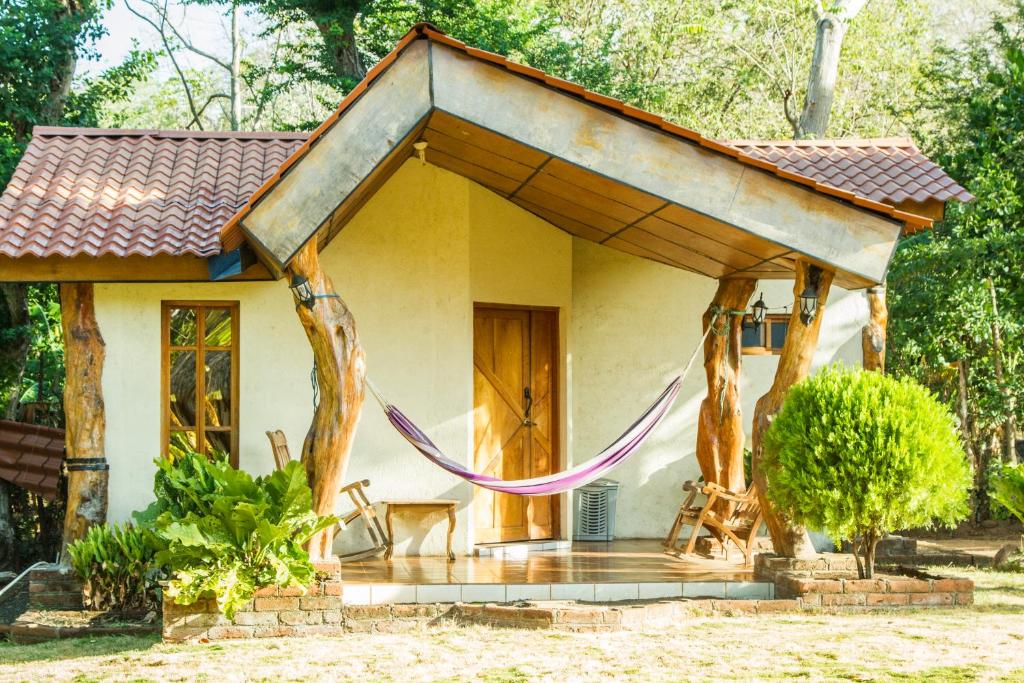 una casa con un porche con una cuerda púrpura alrededor en Hostal y Restaurante Rancho Merida, en Mérida