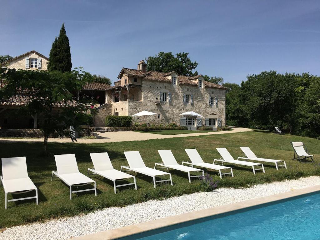 a row of white chairs sitting in front of a house at Les Terrasses de La Serre in Lascabanes