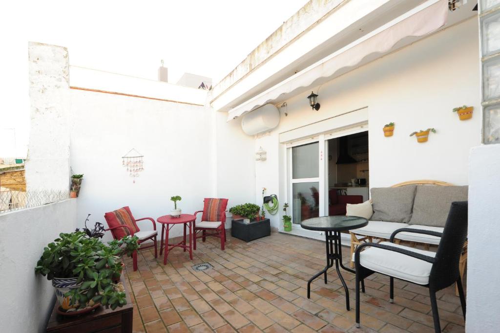 eine Terrasse mit Stühlen, einem Tisch und einem Sofa in der Unterkunft Atico Brisa in Cádiz
