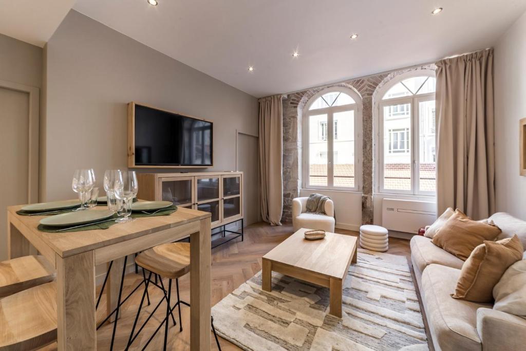 a living room with a couch and a table at Le Chalet climatisé du 6ème in Gare des Brotteaux
