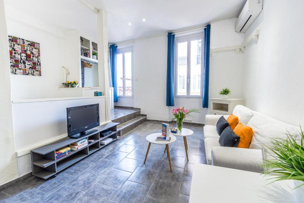 un salon avec un canapé et une télévision dans l'établissement stay-cannes- 1 Bedroom beach & congress apartment, à Cannes