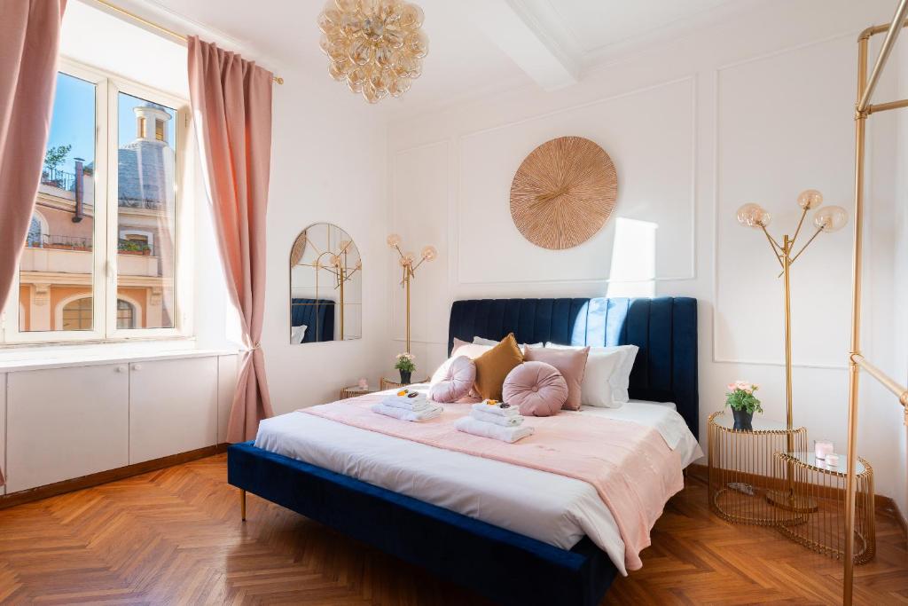 une chambre avec un grand lit avec des oreillers roses dans l'établissement Appartamento Via XXIV Maggio, à Rome