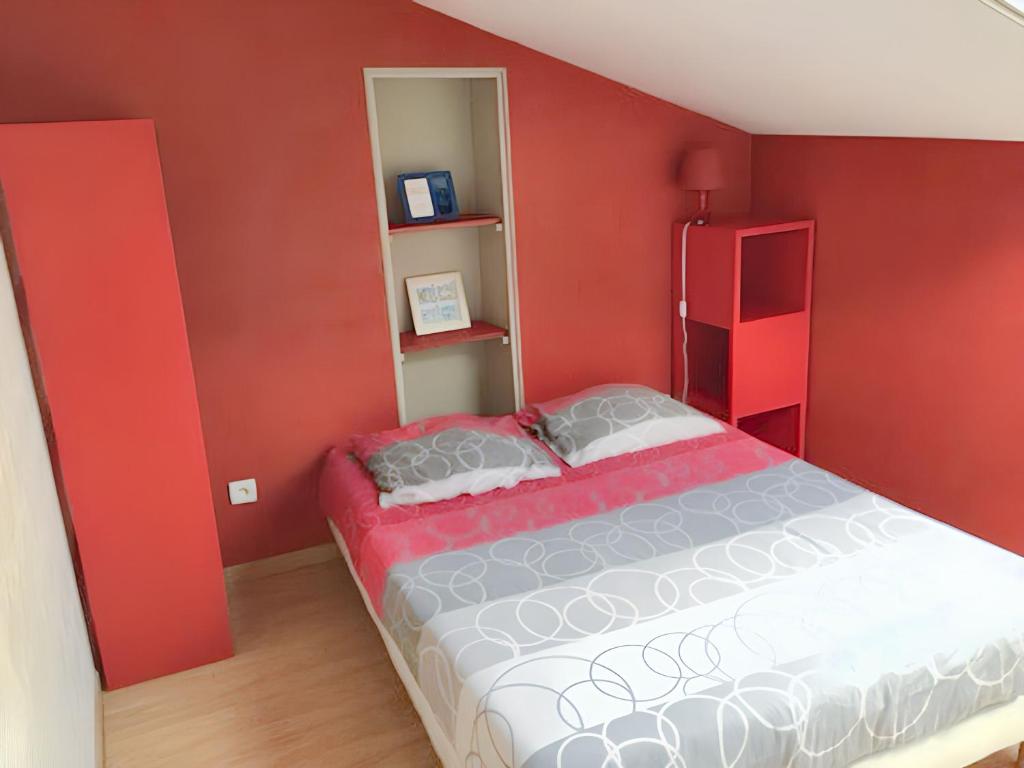 a bedroom with a bed with red walls at Appartement charmant à Roanne, terrasse in Roanne