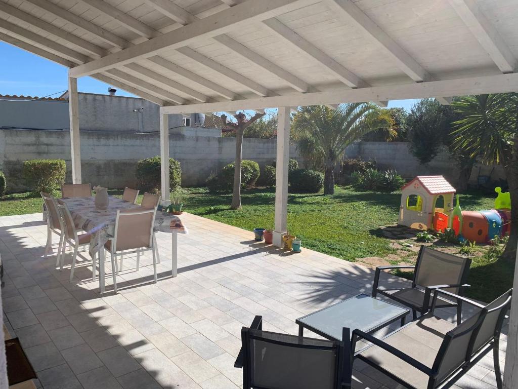 un patio avec une table et des chaises sous un pavillon dans l'établissement Il Giardino di Marta - Villa privata con Piscina, à Contrada Maeggio