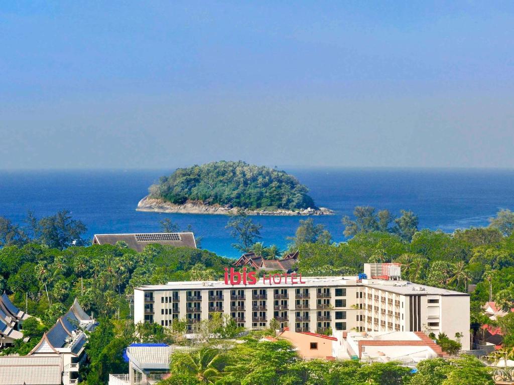 an island in the ocean next to a building at Ibis Phuket Kata in Kata Beach
