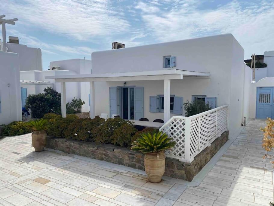 a white house with plants in front of it at Elysia House in Ornos