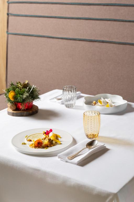 biały stół z talerzami z jedzeniem na nim w obiekcie Grand Hotel Courmayeur Mont Blanc, by R Collection Hotels w mieście Courmayeur