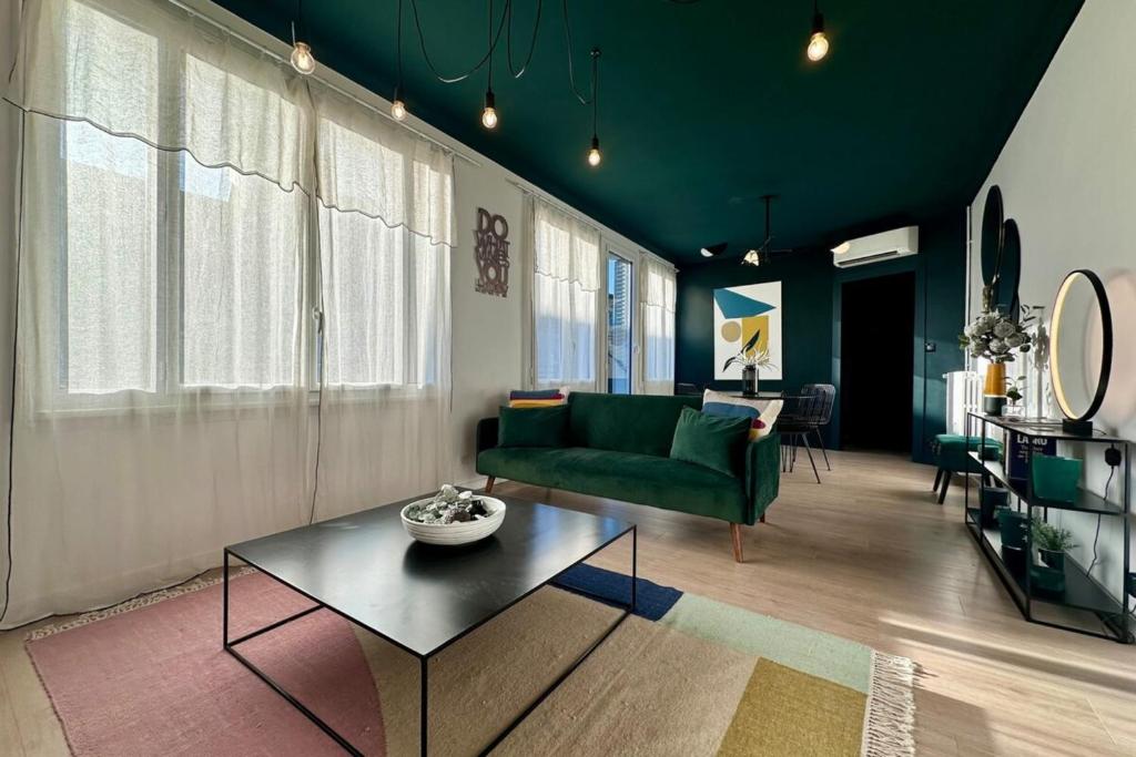 un salon avec un canapé vert et une table dans l'établissement Casa Labrunie - Central T3 avec Garage et Grande Terrasse, à Brive-la-Gaillarde
