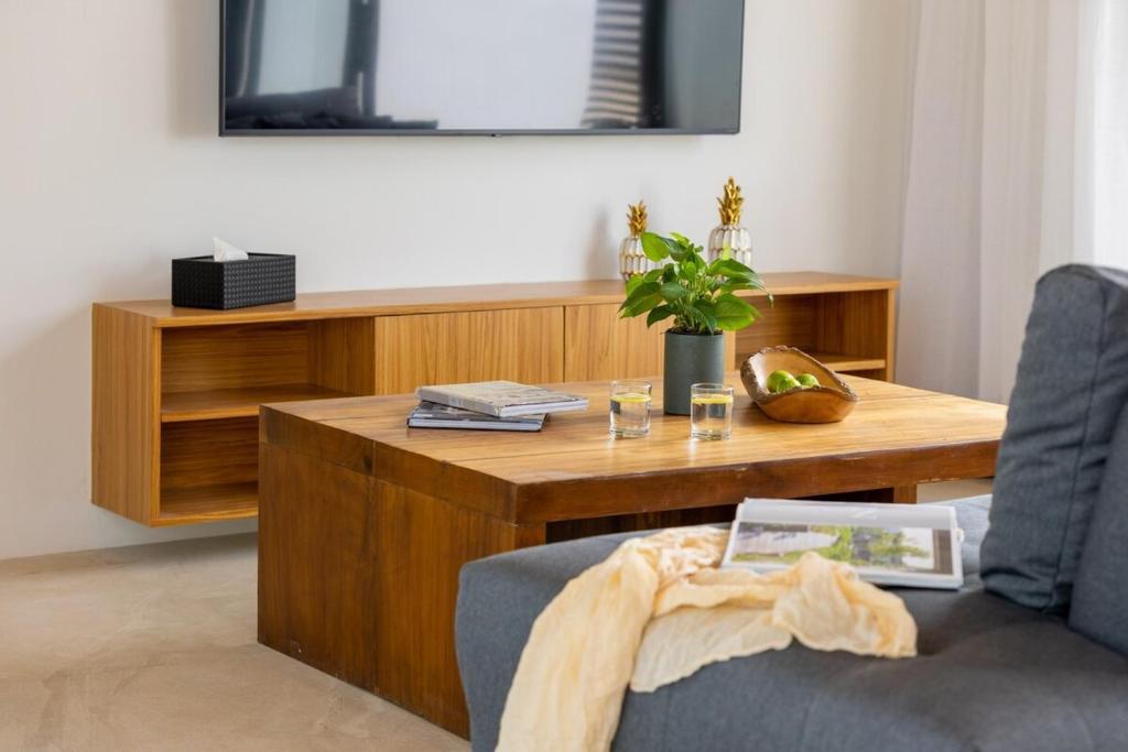 a living room with a wooden coffee table with a chair at Villa Gabriela Garden view - Included Airport pick up in Nathon Bay