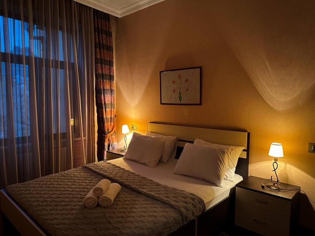 a bedroom with a bed with two slippers on it at Serenity apart by Bakuapart in Baku