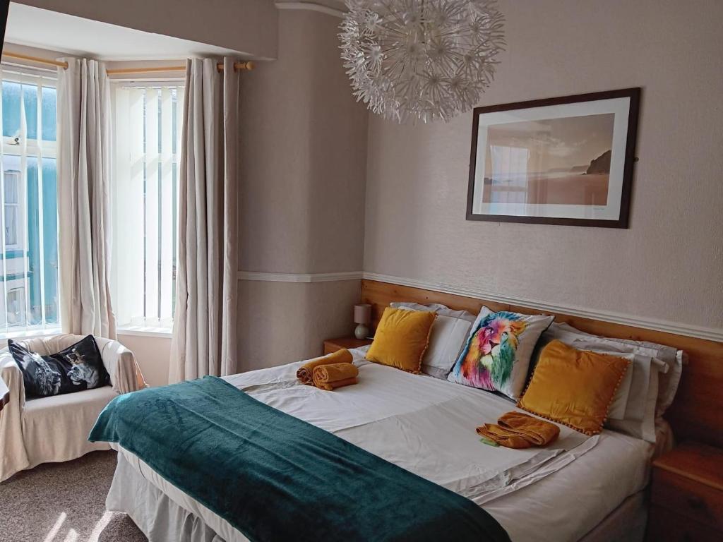 a bedroom with a bed with colorful pillows and a chandelier at The Chorlton by Cherish Lewis Hotel in Blackpool