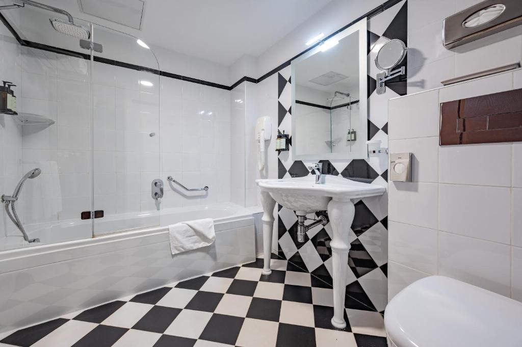 a bathroom with a sink and a tub and a toilet at AX The Victoria Hotel in Sliema