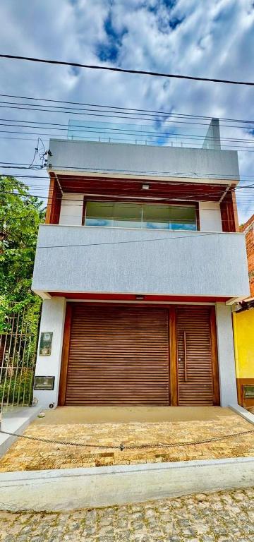 a building with a garage door in front of it at Casa João de Barro in Itacaré