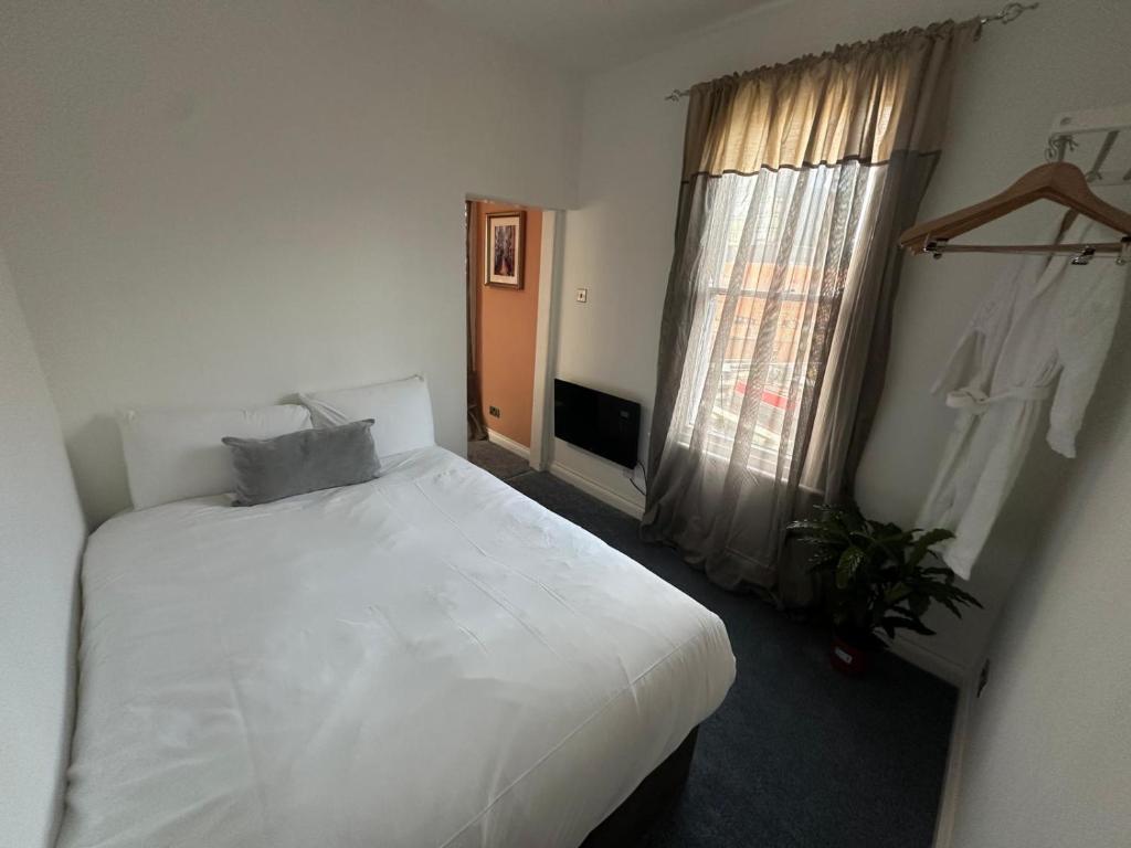 a bedroom with a white bed and a window at Cozy flat by Birmingham Canals & City Centre in Birmingham