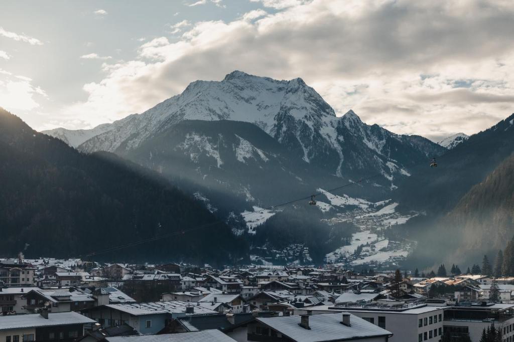 a view of a city with a snow covered mountain at MANNI das Hotel in Mayrhofen