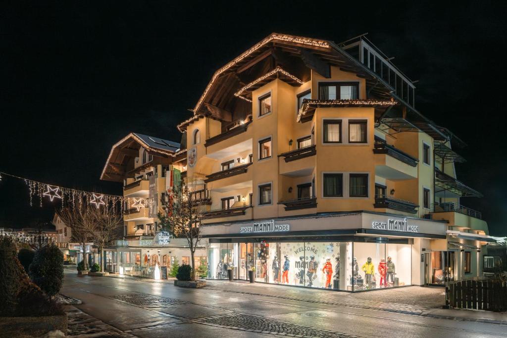 a tall building with a store in front of it at MANNI das Hotel in Mayrhofen