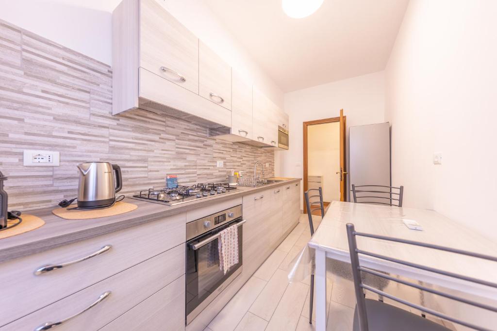 una cucina con piano cottura forno superiore accanto a un tavolo di Easy Host Apt Casa Numitore a Roma