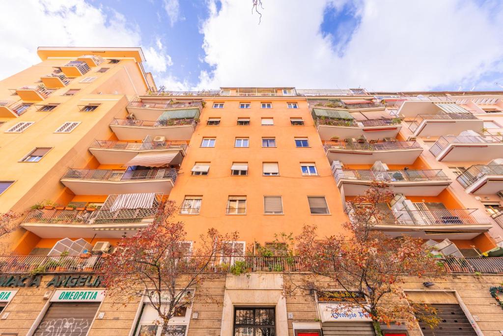 un alto edificio arancione con balconi di Easy Host Apt Casa Numitore a Roma