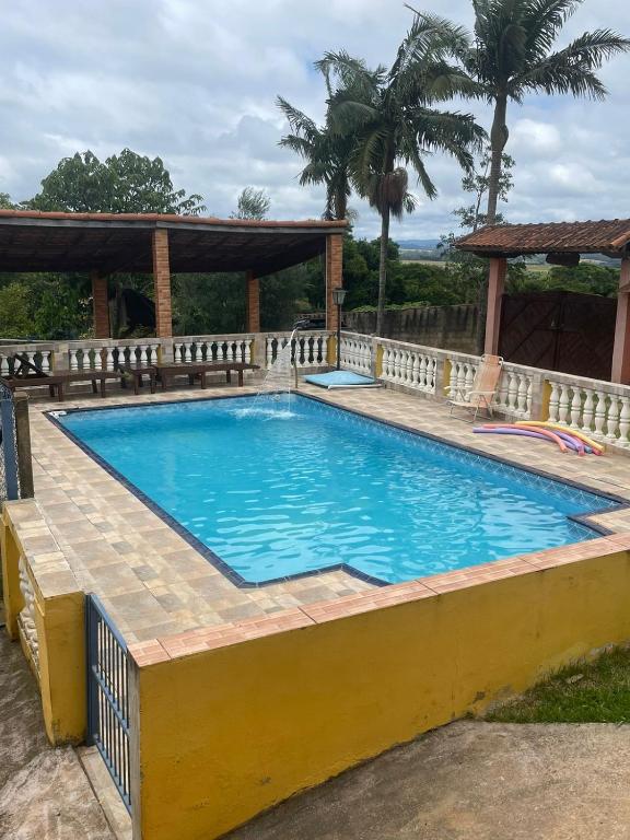 a swimming pool with a wooden fence around it at Chácara São Marcos in Ibiúna
