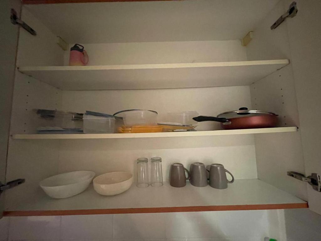 un estante con tazones y utensilios en una cocina en Ultimate luxury Apt in JLT, en Dubái