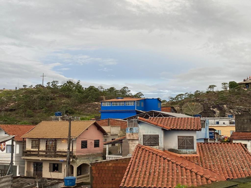 un groupe de toits avec un bâtiment en arrière-plan dans l'établissement Kitnet Girassol, à São Thomé das Letras