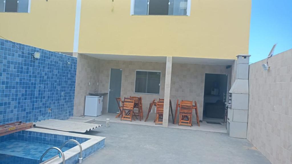 a patio with chairs and a swimming pool next to a building at Casa de praia Jacuipe Condomínio Planeta Água 1 in Campos