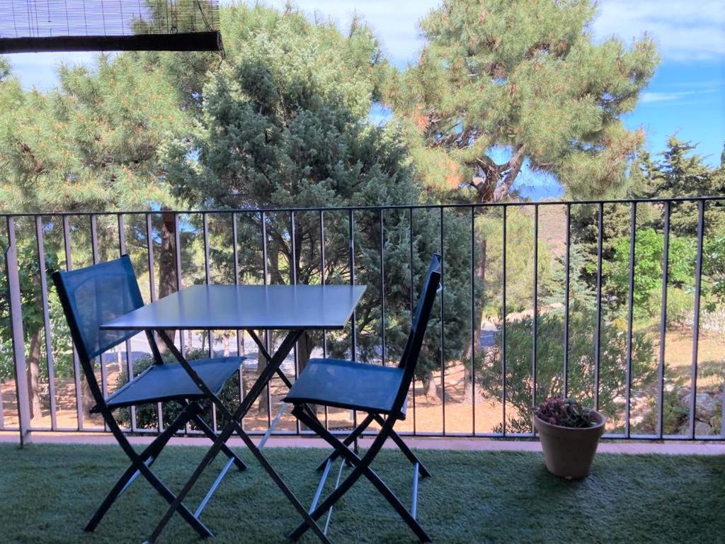 2 chaises et une table en face d'une clôture dans l'établissement Entre mer et montagne à BANYULS-SUR-MER, à Banyuls-sur-Mer