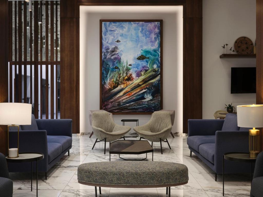 a lobby with blue couches and a painting on the wall at Atlantica Sungarden Park in Ayia Napa