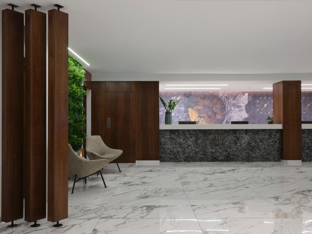 a lobby with chairs and a painting on the wall at Atlantica Sungarden Park in Ayia Napa