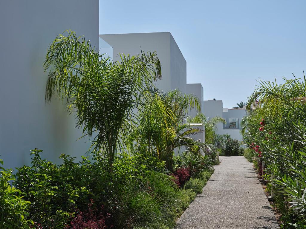a walkway in front of a building with palm trees at Atlantica Sungarden Park in Ayia Napa