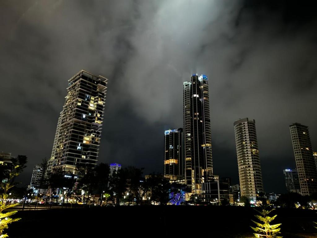 a city skyline with tall buildings at night at 3BR urban suites 8-10pax luxury family stay netflix in Jelutong