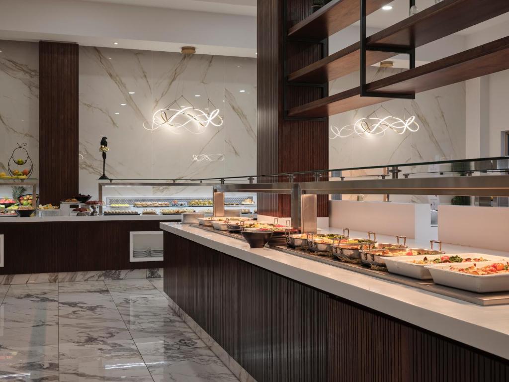 a buffet line in a restaurant with food on display at Atlantica Sungarden Park in Ayia Napa