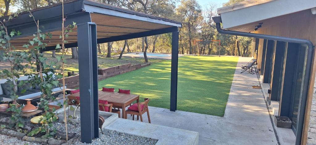 a pavilion with a table and chairs and a lawn at Casa Natura Montseny in El Brull