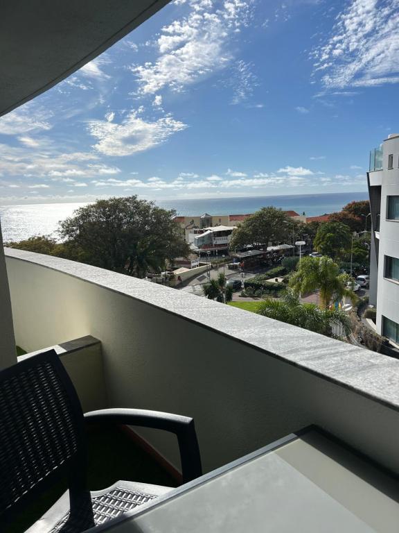 a balcony with a chair and a view of the ocean at Lido Casa by Olá Madeira in Funchal