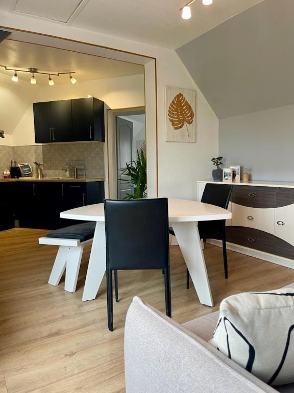 une table blanche et des chaises dans un salon dans l'établissement Naturaë Amentes T2 55M à l' étage, à Saint-Amand-les-Eaux
