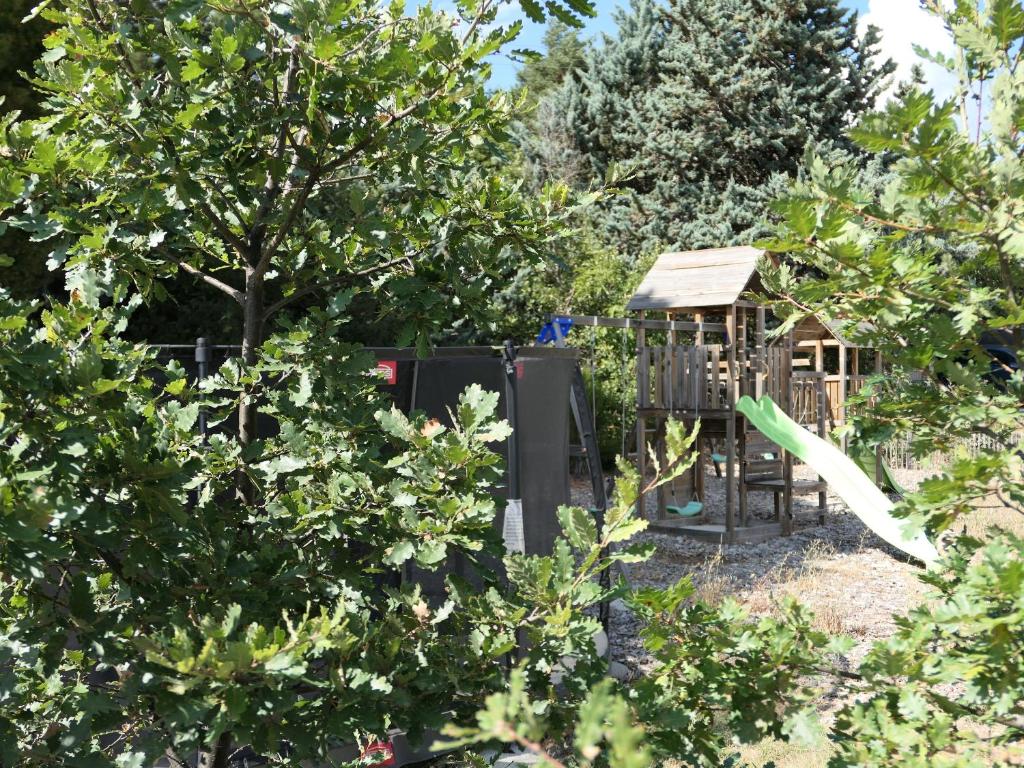 a playground in a garden with a tree at La Grisonne - Chalet 3 in Revest-du-Bion