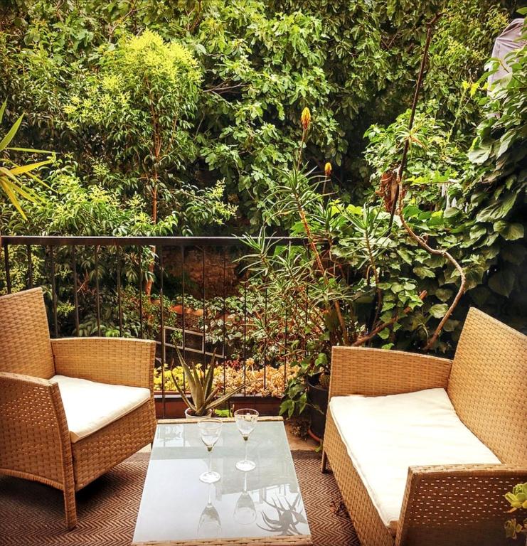 - une terrasse avec 2 chaises et une table avec des verres à vin dans l'établissement Appartement spacieux à Montpellier avec jardin, 78 m², à Montpellier