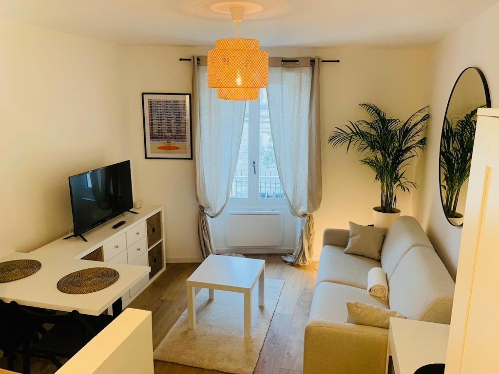 un salon avec un canapé et une télévision dans l'établissement Studio Downtown Private Parking, à Montlhéry