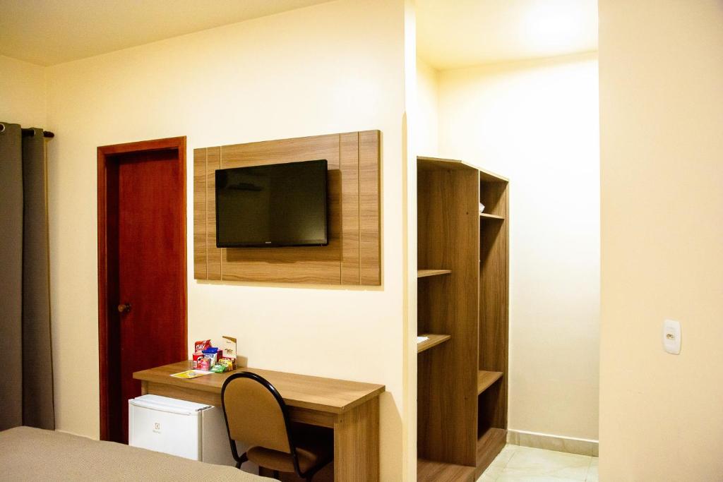 Uma TV ou centro de entretenimento em Fenix Hotel Pouso Alegre
