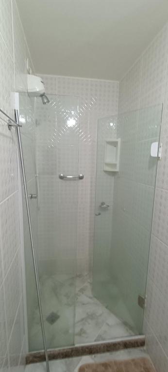 a shower with a glass door in a bathroom at Apartamento 2 quartos - Em frente a praia in Saquarema