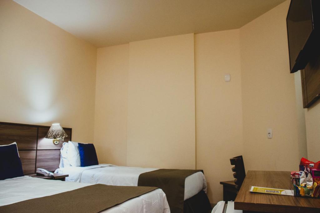 Cama ou camas em um quarto em Fenix Hotel Pouso Alegre