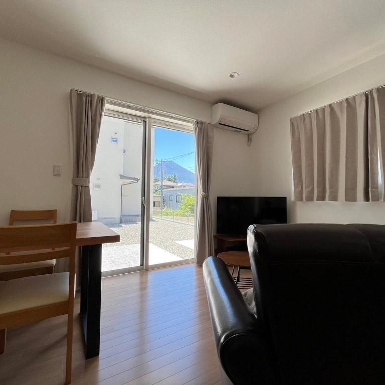 a living room with a couch and a table and a window at Villa ANOTONA No 1 in Fujikawaguchiko